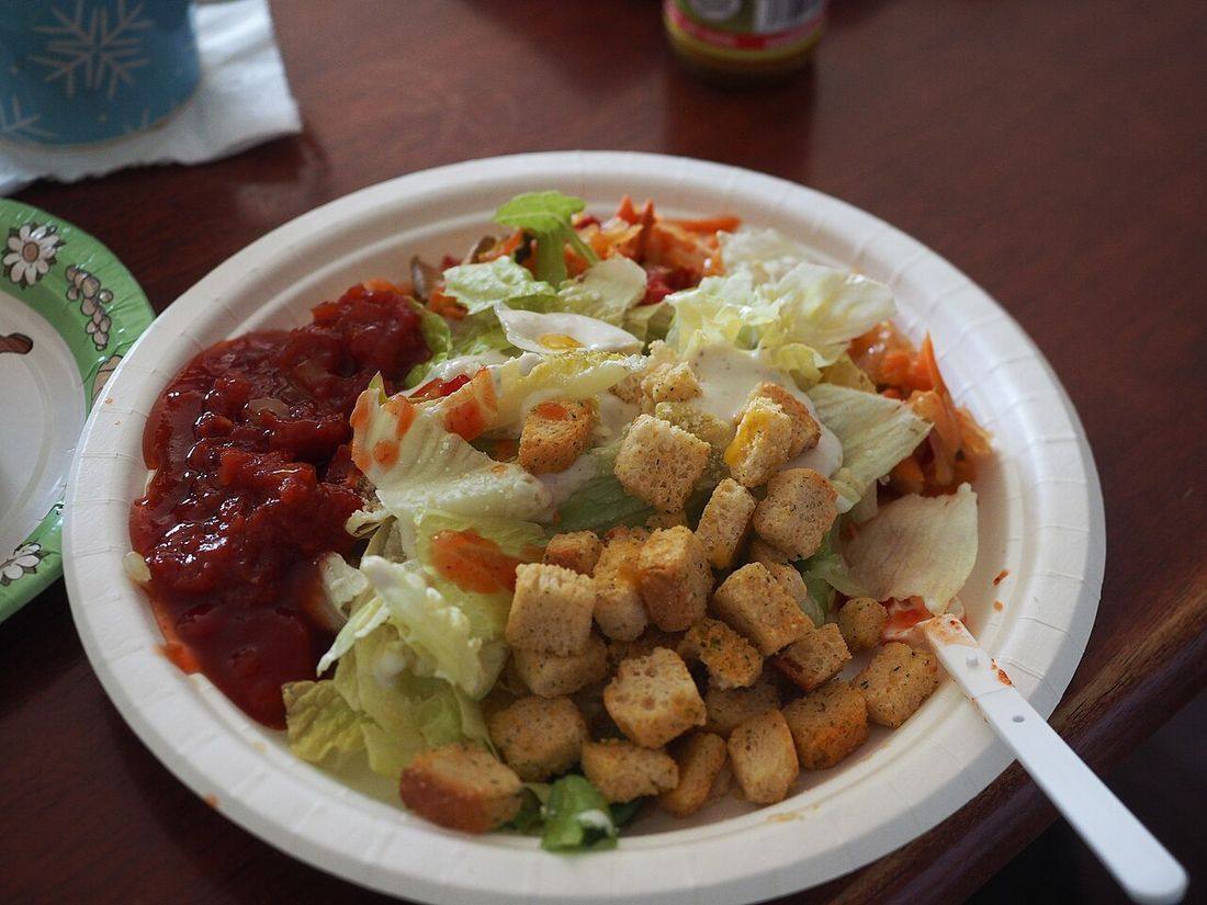 Salad, croutons and salsa on a paper plate