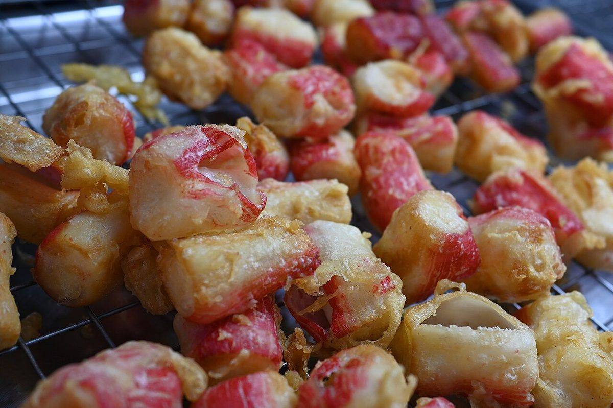DFC 4118 Crispy bite-sized tempura-style crab sticks cooling on a wire rack golden and ready to serv (Imitation Crab)