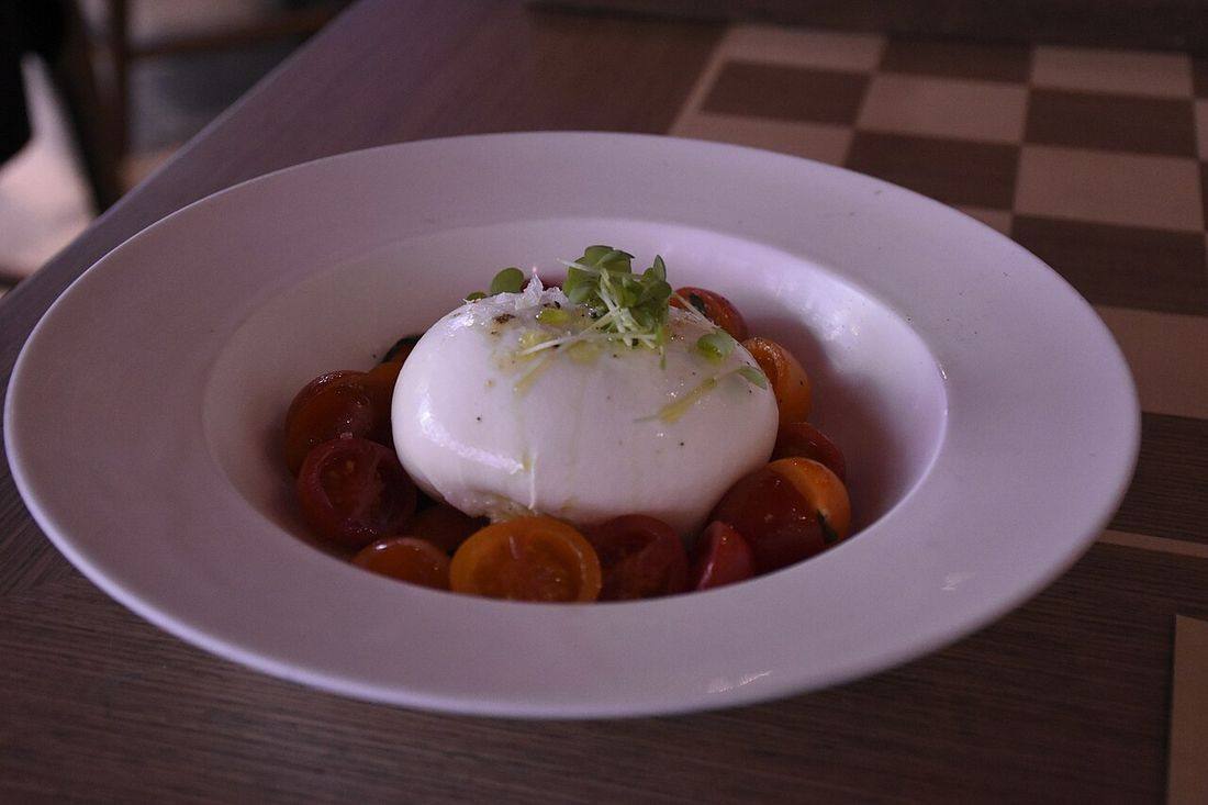 Mozzarella cheese ball with cherry tomatoes and basil