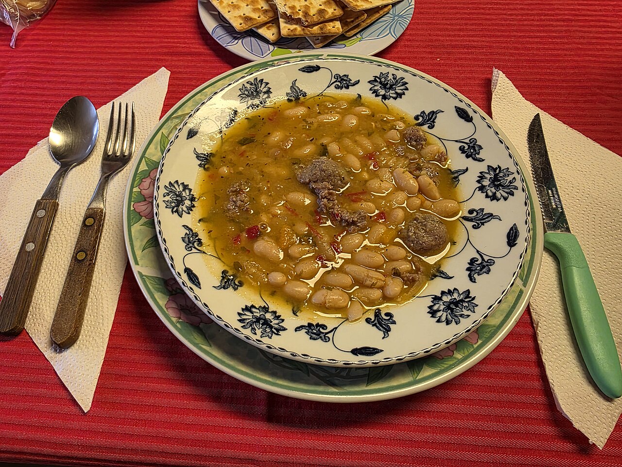 Guiso de porotos blancos alubia con chorizo, morrones rojos, cebollas, perejil, pimienta negra, zanahoria,...