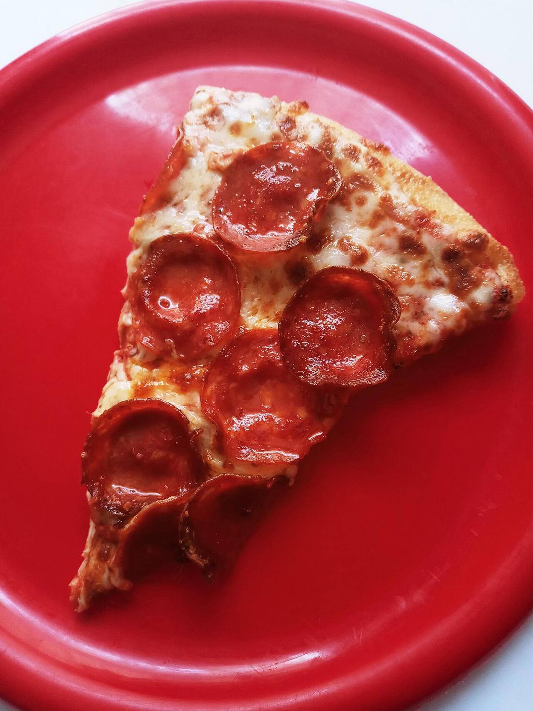 Pepperoni pizza slice on a red plate
