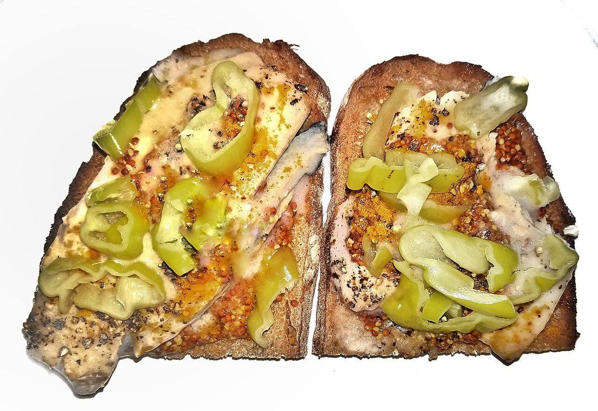 Herring fillets on toasted homemade bread, with mustard, pepperoncini, curry powder, black pepper, a (Pickled Herring)