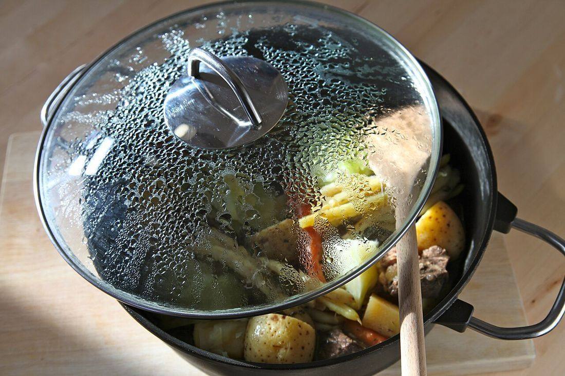 Modern cooking pot with glass cover and vegetable-beef stew (Pot Au Feu)