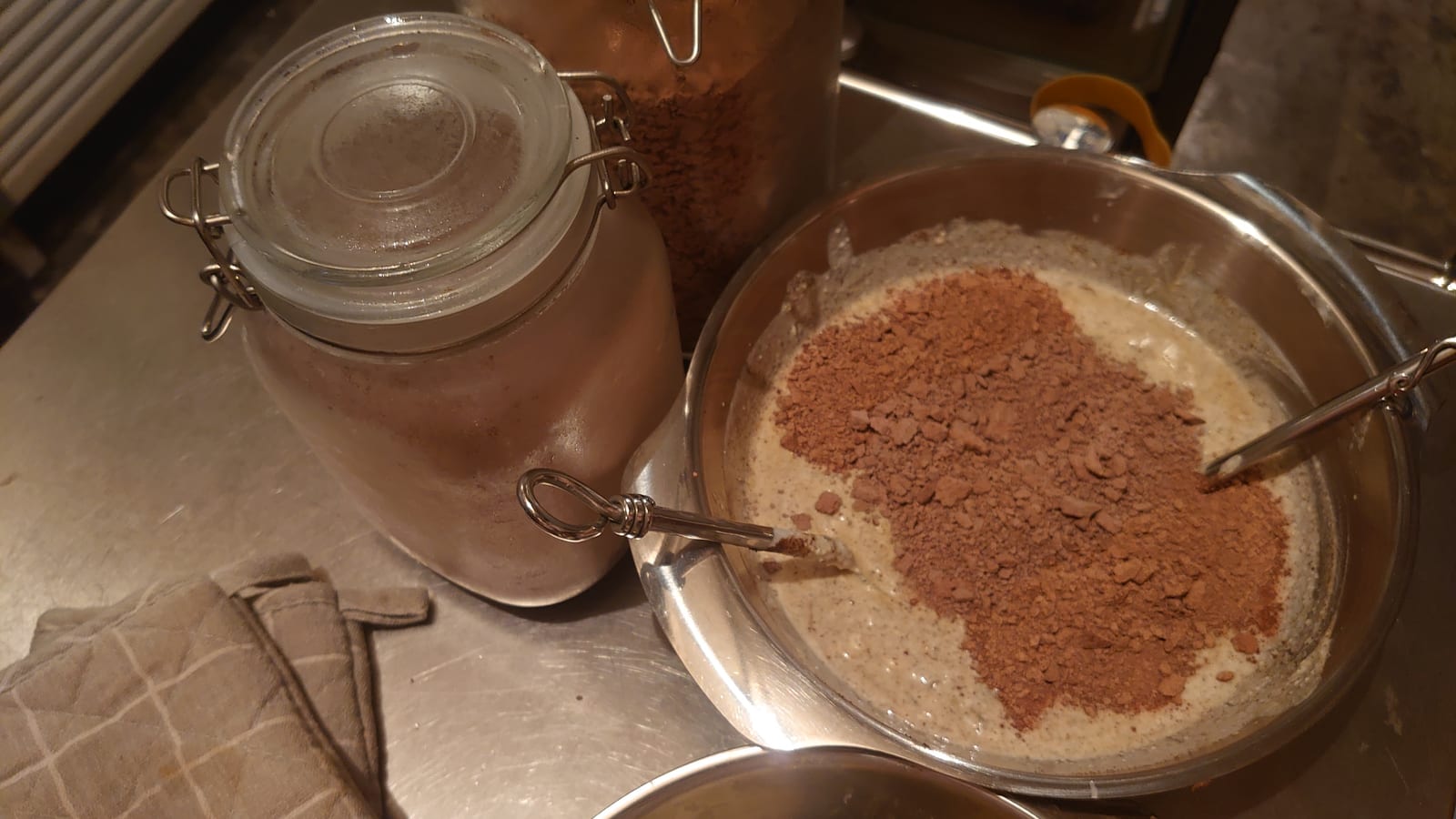 Milk in a glass jar beside a bowl of homemade yoghurt