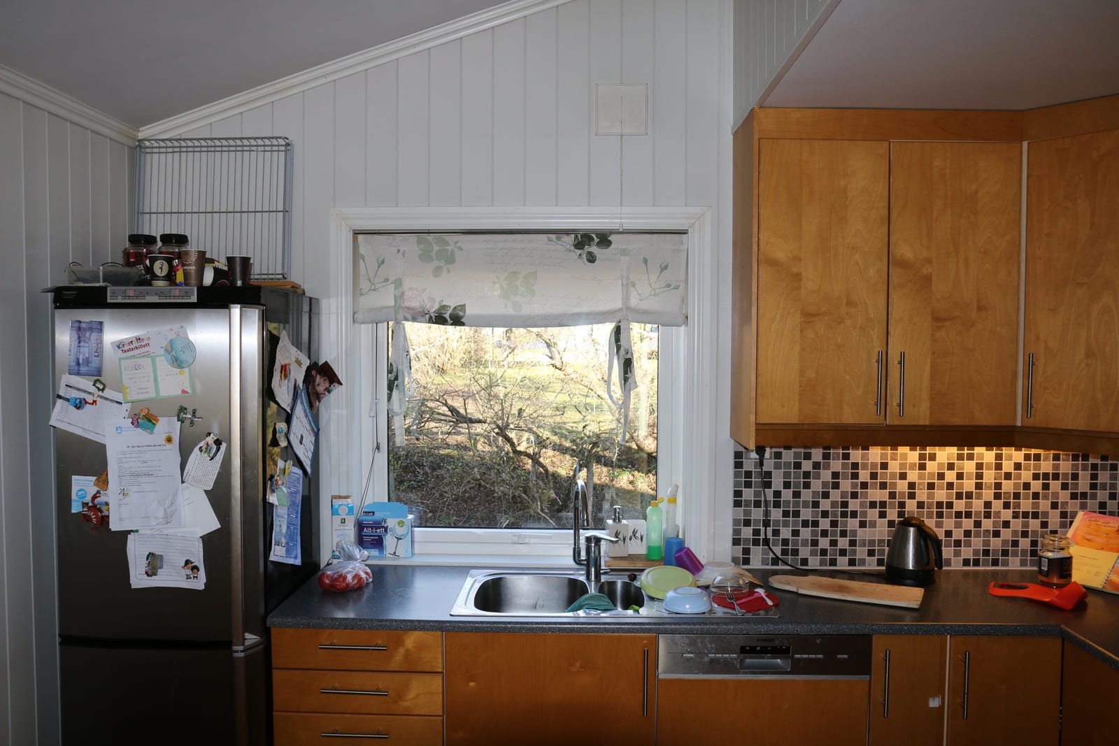 A domestic kitchen with an open refrigerator, where food thaws safely